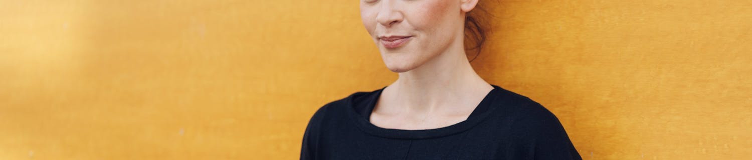 Portrett av kvinne med brun hud og mørkt krøllete hår